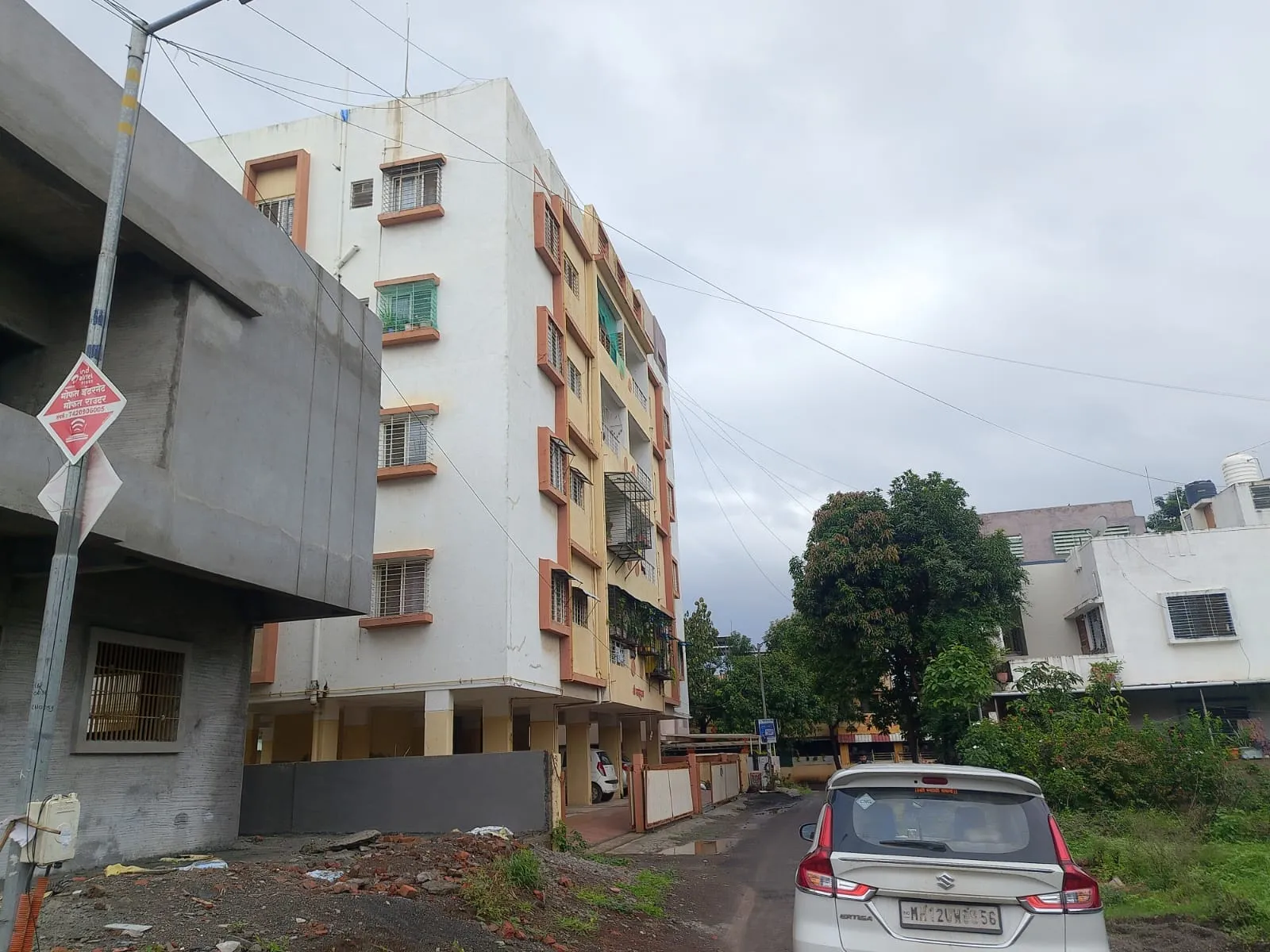 Plot No. 33 alongside an established multi-storey residential building in Adgaon, Gut No. 552